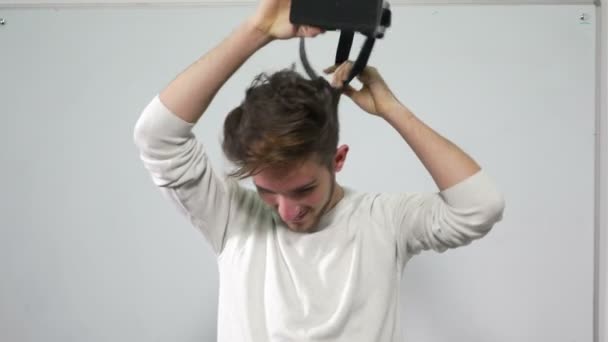 Junger Mann justiert und probiert Virtual-Reality-Brille an — Stockvideo