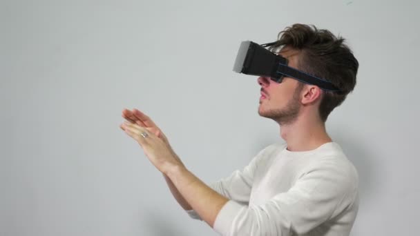 Hombre con auriculares VR entra en un mundo de realidad virtual e interactúa con el medio ambiente — Vídeos de Stock