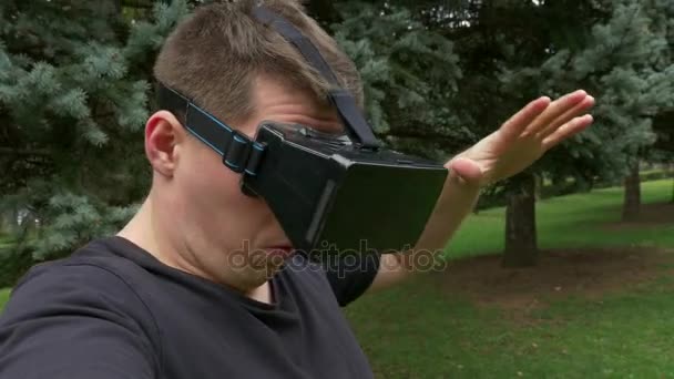 Vr メガネのレンズを通して屋外周りを見て大人の男 — ストック動画