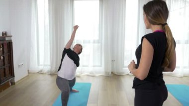 Bir öğrenci bir yoga sırası yapıyor izlerken yoga öğretmeni