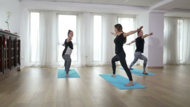 İki öğrenenler Yoga sıra onlara rehberlik öğretmeniyle pratik