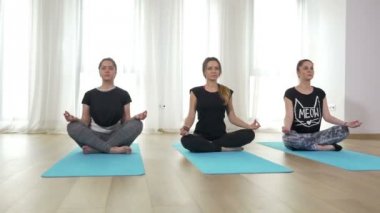 Meditasyon ve lotus bulunduğu kapalı yoga dersinde duran kadın