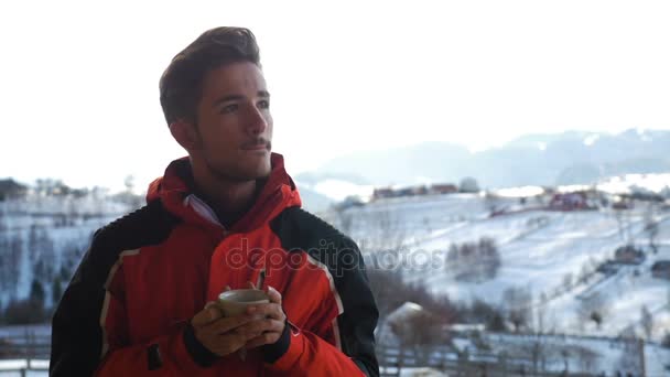 Bello turista uomo sopping espresso caldo su un ponte in inverno in montagna — Video Stock