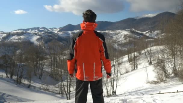 Ο άνθρωπος που απολαμβάνει μια υπέροχη ηλιόλουστη μέρα το χειμώνα στην κορυφή των βουνών — Αρχείο Βίντεο