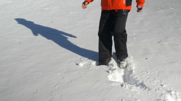 Jovem jogando-se na neve e fazendo anjos de neve — Vídeo de Stock