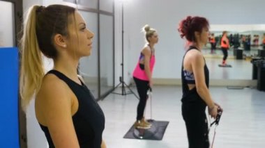 Spor salonunda egzersiz fitness ekipmanları giymiş genç çekici kadınlar