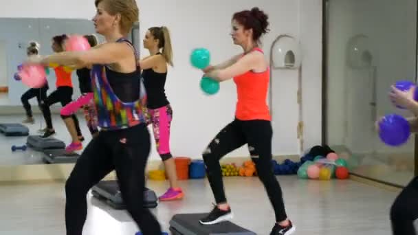 Frauen trainieren im Fitnessclub mit Stepper und Bällen in der Hand — Stockvideo