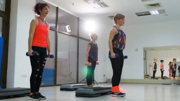 Çekici kadın spor salonunda dumbbells ile ağız kavgası yapıyor — Stok video