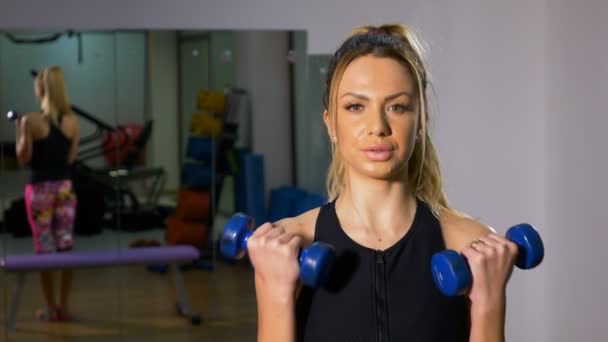 Güçlü kadının dumbbells ile vücut geliştirme egzersiz yapması portresi — Stok video