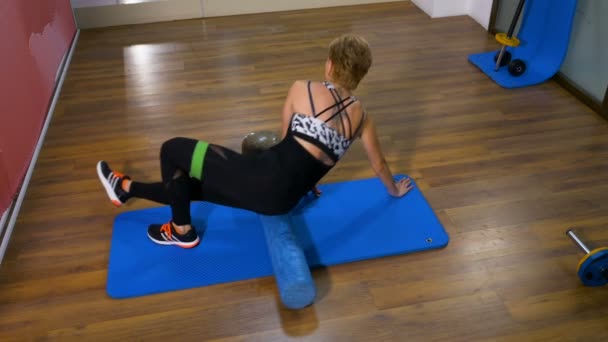 Женщина делает упражнения на позвоночник в тренажерном зале — стоковое видео