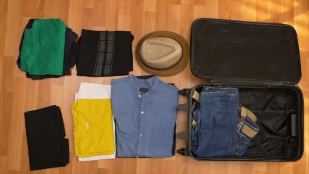 Timelapse vue du dessus de l'emballage des vêtements dans une valise — Video