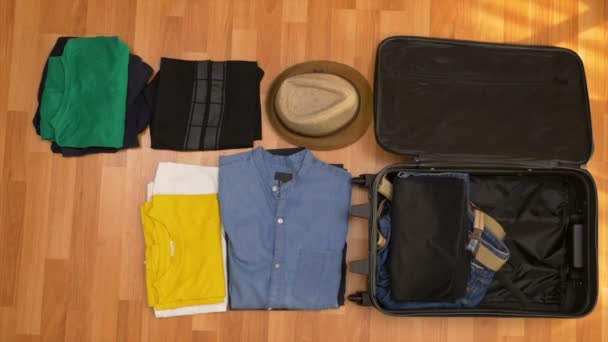 Vista superior timelapse de embalaje de ropa en una maleta — Vídeo de stock