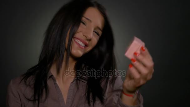 Mujer sosteniendo una pequeña caja de regalo en su mano y mostrándola a la cámara — Vídeos de Stock