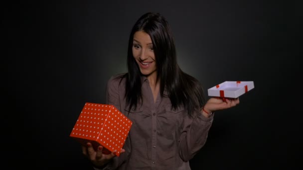 Mujer joven abriendo una caja de regalo y dejándose sorprender por el presente — Vídeos de Stock
