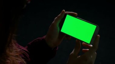 Karanlıkta akıllı telefon kullanan kadın