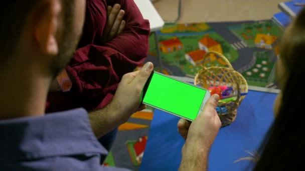 Grupo de adolescentes assistindo um telefone inteligente com tela verde em uma oficina — Vídeo de Stock