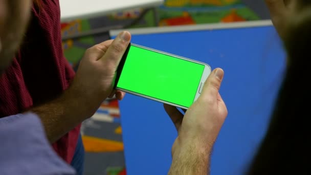 Homem segurando telefone inteligente com tela verde e apresentando em uma reunião — Vídeo de Stock