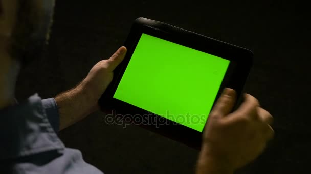 Een zakenman houdt groen scherm tablet pc in de hand en snel jatten op het display — Stockvideo