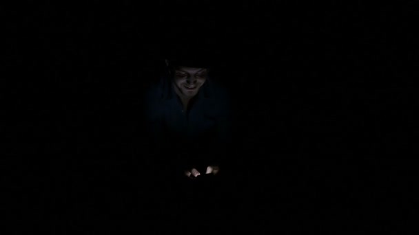 Человек один в темноте пишет смс на смартфоне иллюстрируя концепцию технологических рабов — стоковое видео