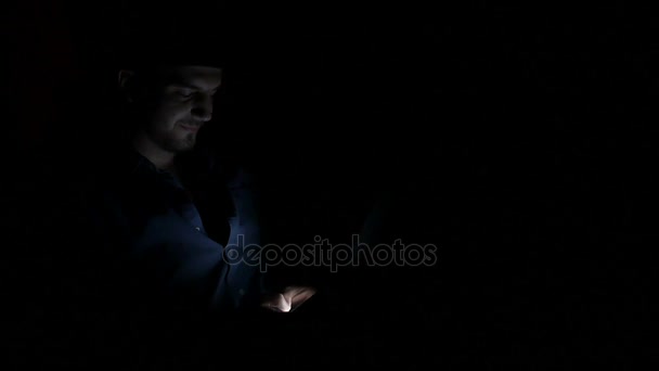 Lonely guy spending time in the dark and chatting on smart phone on social media — Stock Video