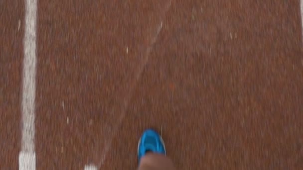 Primer plano cámara lenta pov de un deportista pies corriendo en una pista de atletismo — Vídeos de Stock