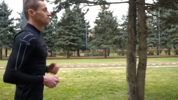 Movimiento lento del hombre atlético corriendo en el parque — Vídeos de Stock