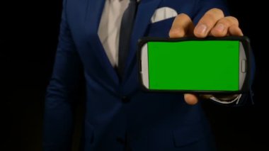 Yeşil ekran akıllı telefon tutarak ve sergilenen parmakla işaret eden bir adamın elini
