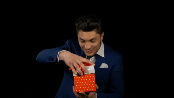 Handsome attractive young man opening gift box and showing it to the camera — Stock Video