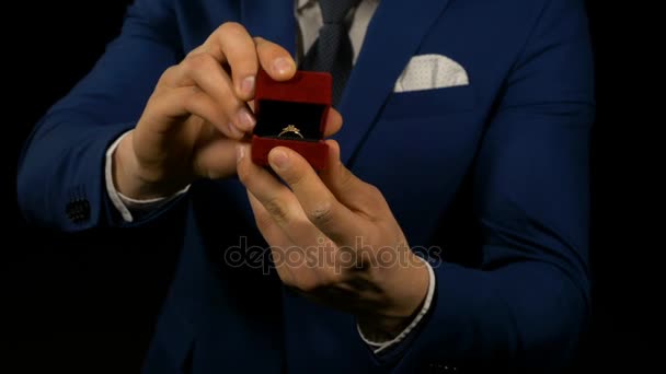 Manos de hombre elegante sosteniendo y presentando joyero con anillo en el interior — Vídeo de stock