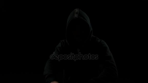 Таинственный человек в капюшоне боксирует в темноте — стоковое видео