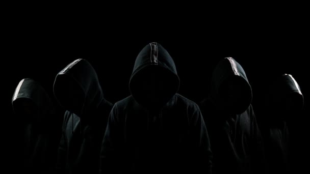 Fem mystiska hooded män stående i mörk hoodies och dolda ansikten — Stockvideo