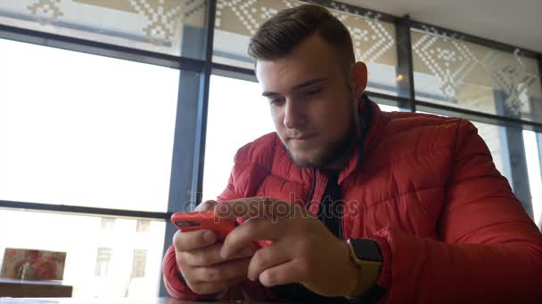 Adolescent naviguant sur les médias sociaux sur un écran tactile de téléphone intelligent et en utilisant smartwatch — Video