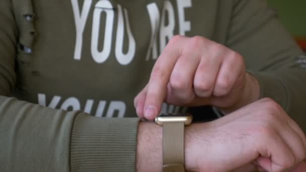 Primer plano del hombre interactuando con smartwatch en un restaurante — Vídeos de Stock