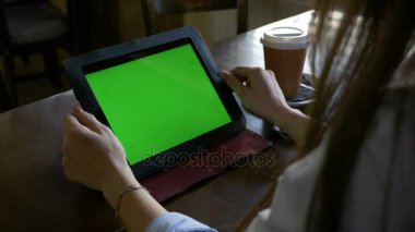 Öğrenci kütüphanede okuma ve yeşil ekran tablet PC'de eğitim ve kahve içer
