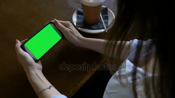 パブで昼休みに彼女の緑色の画面のスマート フォンでインターネットをサーフィン若いセクシーな女性 — ストック動画
