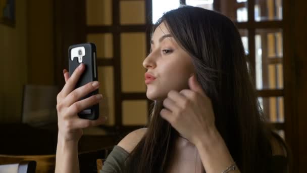 Perfil de cerca con sensual joven mujer usando su cámara de teléfono inteligente para retocar su maquillaje — Vídeos de Stock