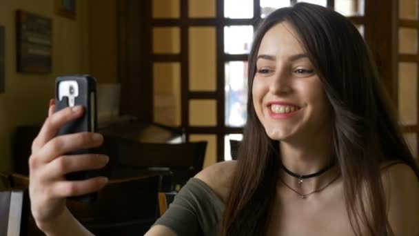 Młoda kobieta o rozmowę wideo z kawiarni — Wideo stockowe