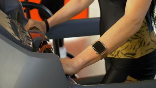 Sportieve vrouw dragen smartwatch doen sport activiteit op loopband — Stockvideo