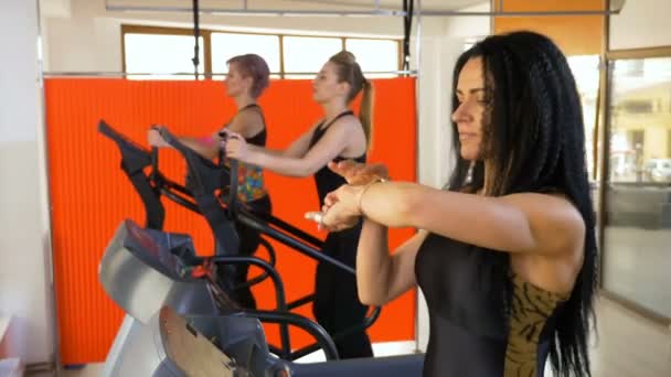 Vrouw trainer in de sportschool controleren puls aan smartwatch en lopen op de loopband met behulp van fitness app — Stockvideo