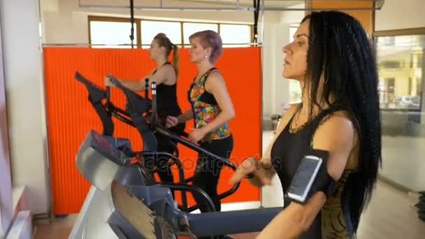 Fitness instructor training on the treadmill setting up smartphone tracking app — Stock Video