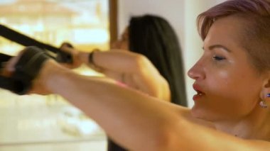 Closeup uygun kadın fitness merkezinde kablo makine çekerek triceps kasları eğitim