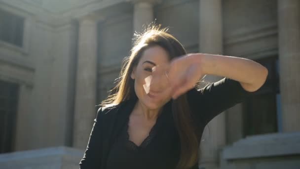 Молодая женщина машет руками в воздухе, прощаясь или здороваясь — стоковое видео