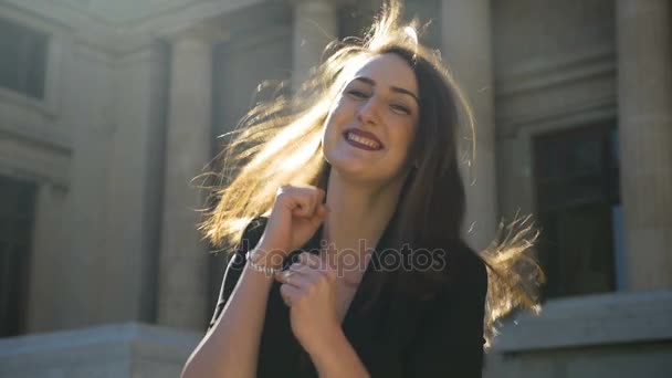 Молодая счастливая девушка танцует, прыгает и прыгает полной радости в городе в замедленной съемке — стоковое видео