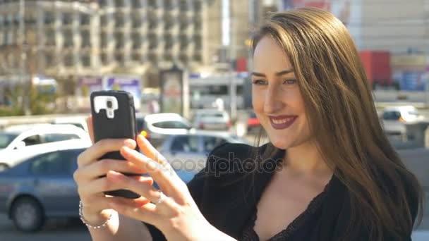 Zakenvrouw nemen van selfies met smartphone camera met stadsverkeer straat op achtergrond — Stockvideo