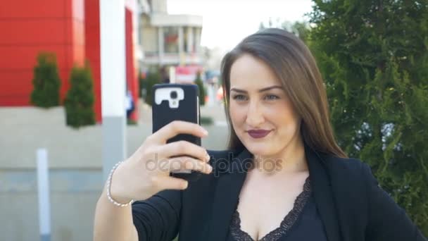 Primo piano della giovane donna d'affari urbana che si fa selfie con lo smartphone in città — Video Stock