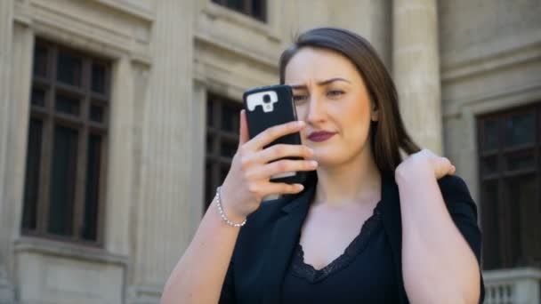 Une belle adolescente fixe ses cheveux et prend un selfie avec caméra smartphone jouer triste — Video
