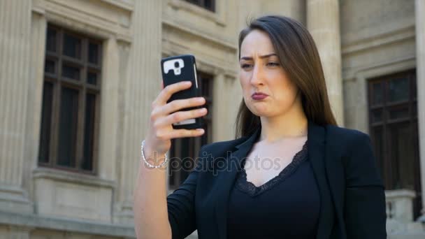 Портрет женщины, держащей смартфон и делающей селфи с грустным лицом — стоковое видео