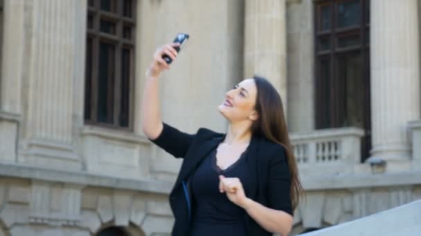 ソーシャル メディアの仮想ネットワークに当座預金口座 selfie ダンスと彼女の後に喜びを表現するを取っている都市女の子 — ストック動画