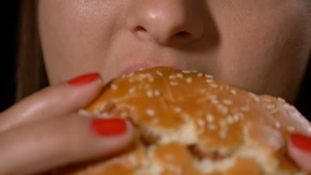 Nahaufnahme des weiblichen Mundes, der einen langen Bissen nimmt und Junk-ungesunden Fast-Food-Hamburger isst — Stockvideo