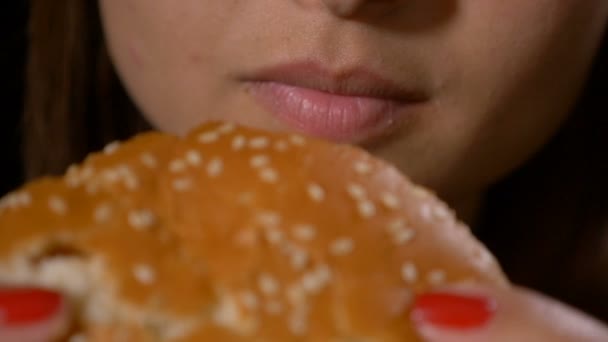 Lento movimento close-up de fome jovem mulher comer lixo insalubre fast food sanduíche hambúrguer — Vídeo de Stock